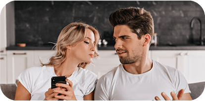 Happy couple in kitchen looking at phone together