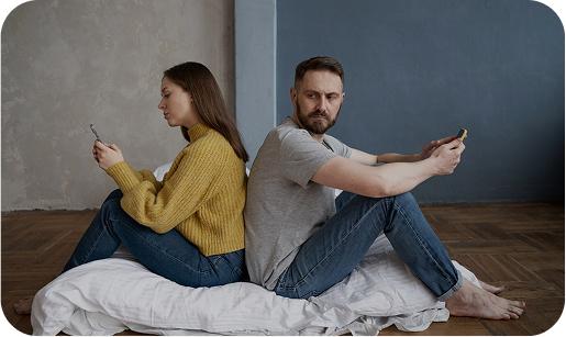 Couple on couch looking at phones disconnected